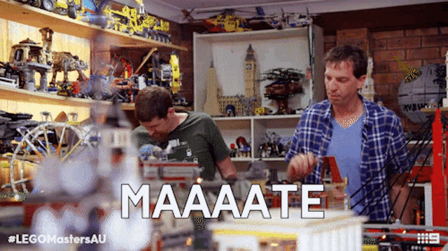 two men are working in a room with the word maaaate written on the bottom
