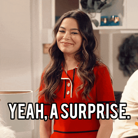 a woman in a red shirt is smiling and says " yeah , a surprise "