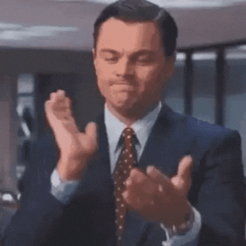 a man in a suit and tie is applauding .