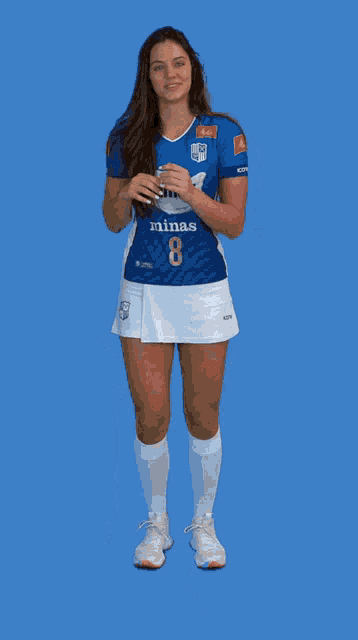 a woman wearing a blue shirt that says minas 8 on it