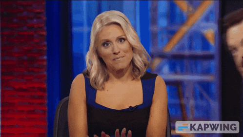 a woman in a blue dress is sitting in front of a screen that says kapwing