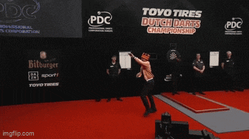 a man is throwing a dart in front of a sign that says toyo tires dutch darts championship