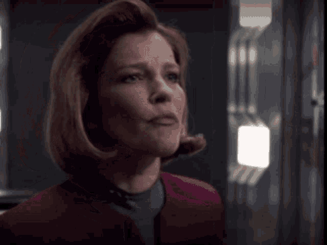 a close up of a woman 's face with a purple jacket on