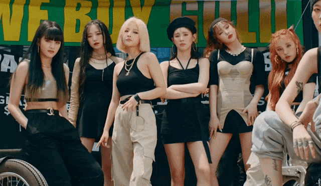 a group of girls standing in front of a sign that says we buy