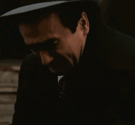 a man in a suit and tie is covering his ears