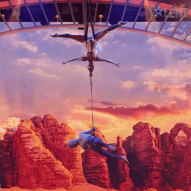 a man and a woman perform aerial acrobatics in front of a bridge with the word talent on it