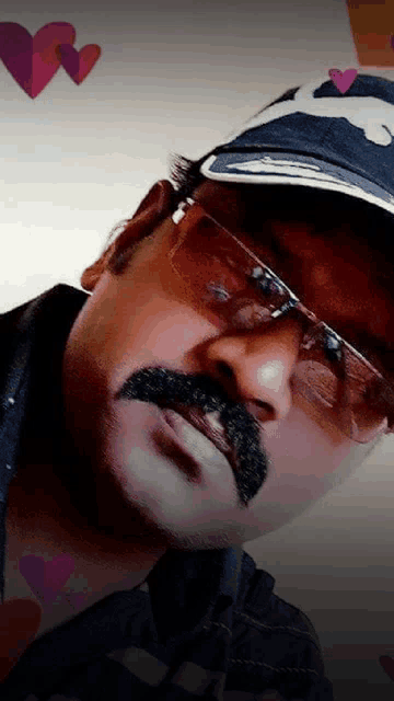 a man wearing glasses and a hat has a mustache painted on his face