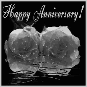 a black and white photo of two white roses with the words happy anniversary