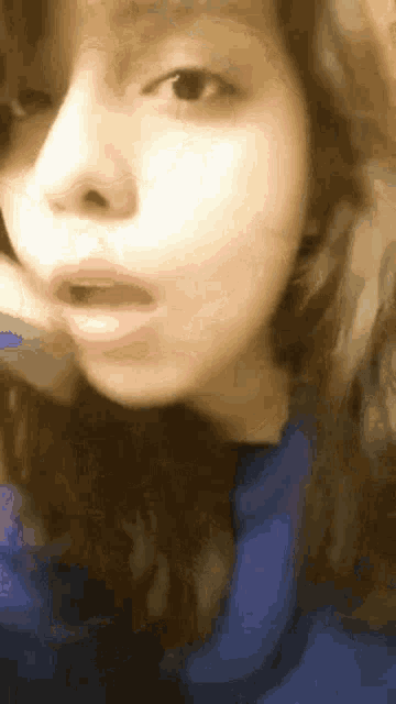 a close up of a woman making a funny face with her mouth open .
