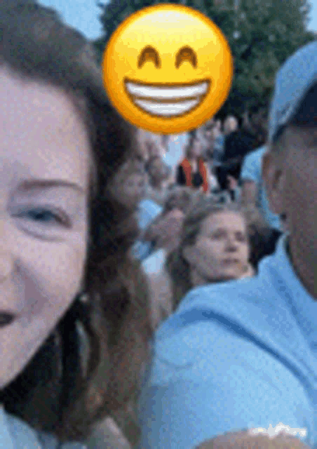a woman with a smiley face on her head is smiling