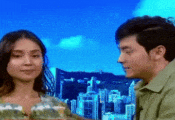 a man and a woman are looking at each other in front of a cityscape