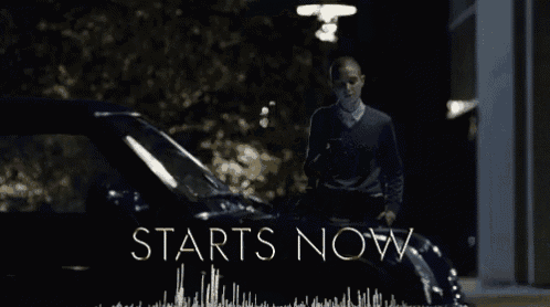 a man standing in front of a car with the words starts now written on the bottom
