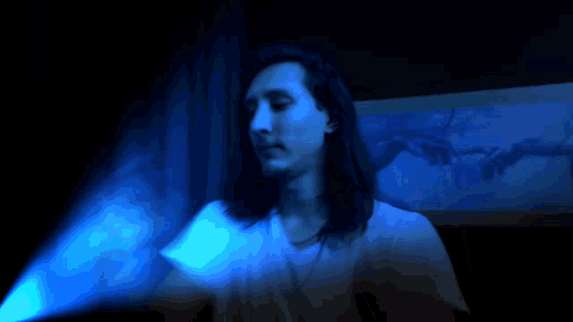 a blurry image of a person with a blue light behind them