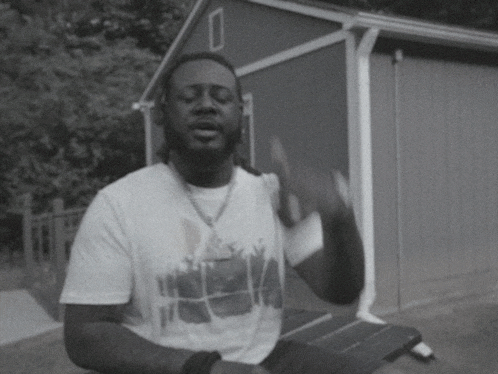 a black and white photo of a man wearing a t-shirt with the word hawaii on it