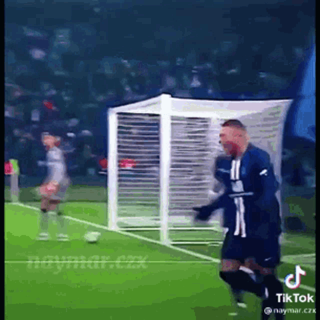a soccer player is running towards a goal on a field