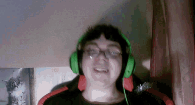 a man wearing green headphones is smiling in front of a calendar