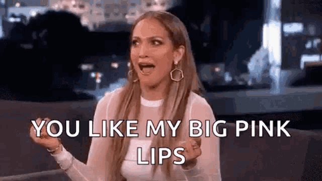 a woman is sitting on a couch with her mouth open and says `` you like my big pink lips '' .