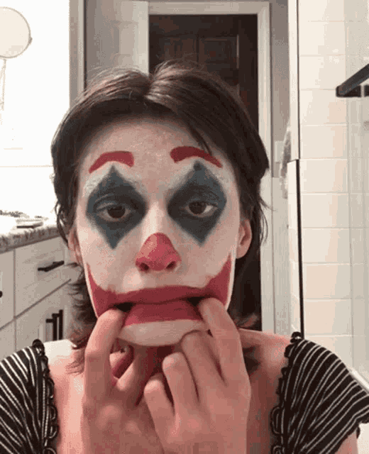a woman has her face painted like the clown from the joker movie
