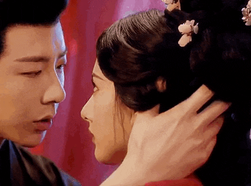 a man is touching the head of a woman in a traditional costume .