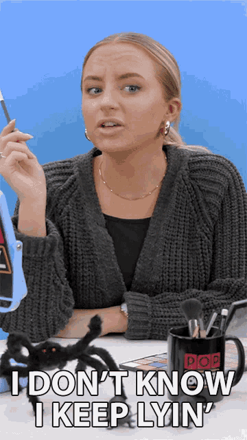 a woman is sitting at a desk with a spider and a mug that says pop on it