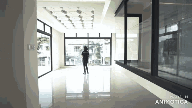 a woman stands in an empty room with the words made in animotica below her
