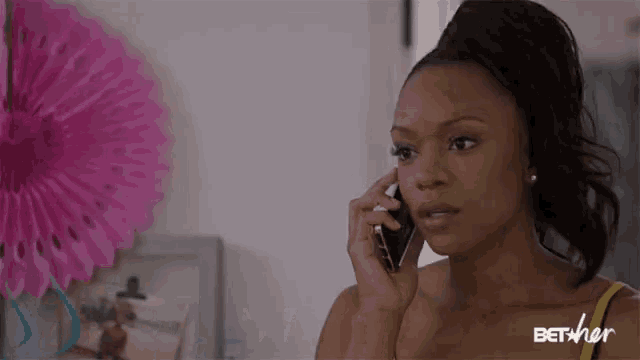 a woman talking on a cell phone with bet her written on the bottom right