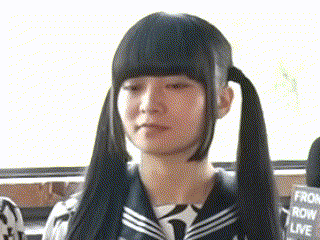 a girl with pigtails and bangs is wearing a sailor uniform and looking at the camera .