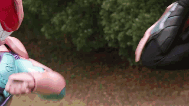 a close up of a person in a superhero costume kicking another person in the face .