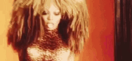a close up of a woman with a wig on her head .