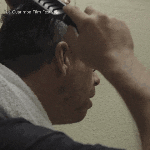 a man brushes his hair with the words la guarimba film festival visible