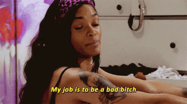 a woman with a tattoo on her arm is saying my job is to be a bad bitch