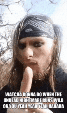 a man with long hair and a bandana on his head .
