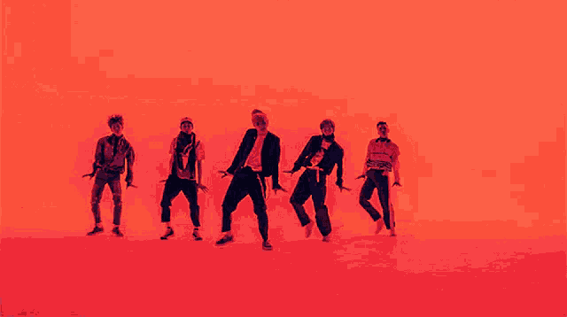 a group of young men are dancing in front of a red background