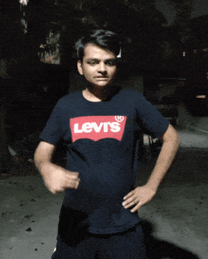 a young man wearing a black levi 's t-shirt stands with his hands on his hips