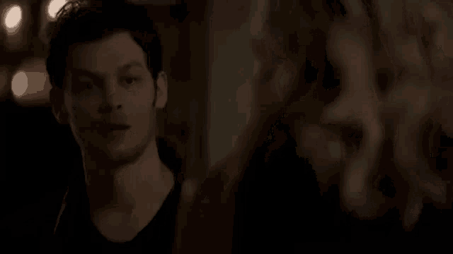 a man and a woman are looking at each other in the dark .