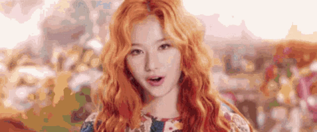 a woman with red hair is standing in front of a blurry background .