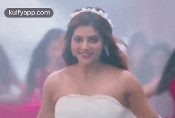 a woman in a white wedding dress is dancing in a room .