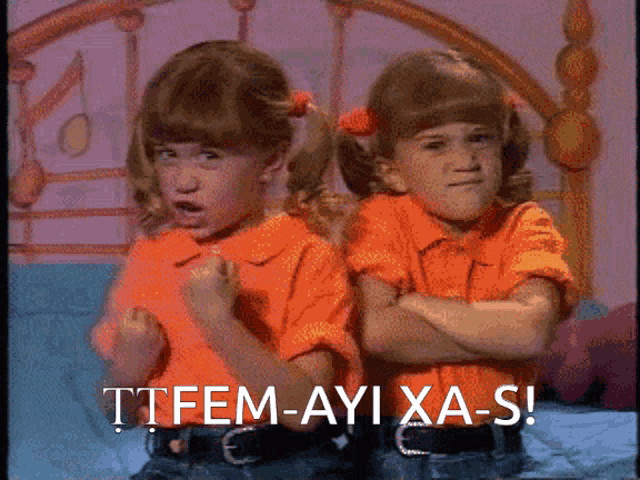 two little girls are standing next to each other with the words ttfem-ayi xa-s written on the bottom