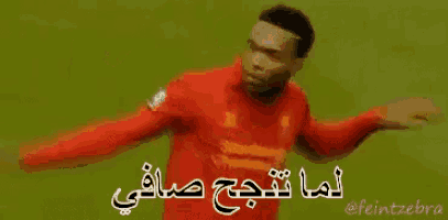 a soccer player wearing a red jersey that says liverpool on it