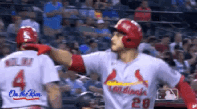 two cardinals baseball players are standing next to each other on a field