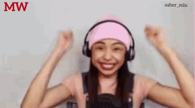 a girl wearing headphones and a pink hat with the word mw on the bottom right