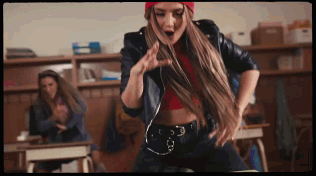 a woman in a red hat and black jacket is dancing