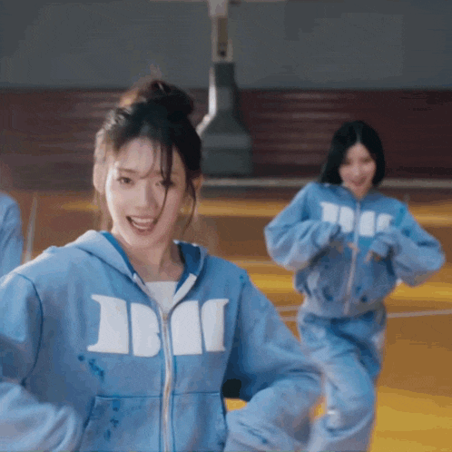 a girl wearing a blue hoodie with the letter b on the front
