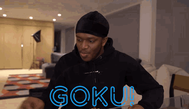 a man wearing a black hoodie with goku written on it