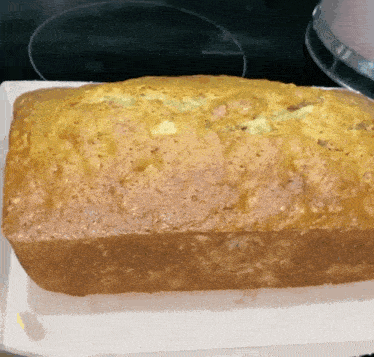 a loaf of banana bread is sitting on a white plate