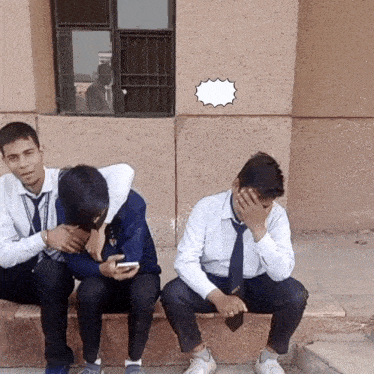 three young men are sitting on the steps of a building with one covering his face with his hand