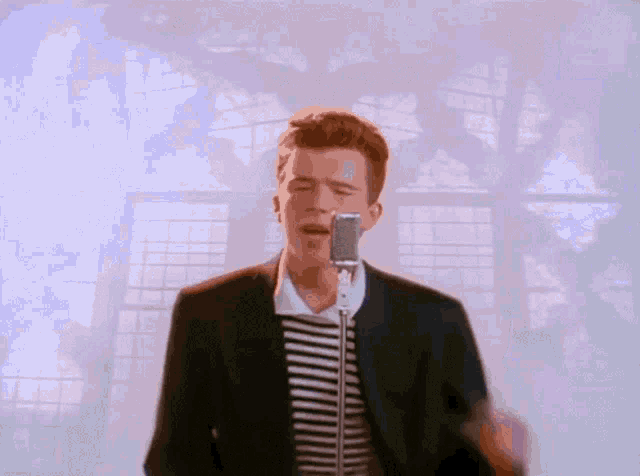 a man singing into a microphone with a striped shirt on