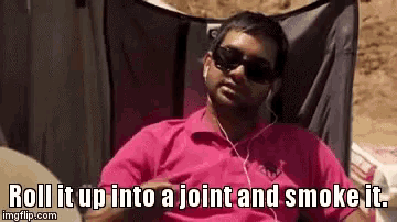 a man in a pink shirt is sitting in a chair and smoking a joint while listening to music .