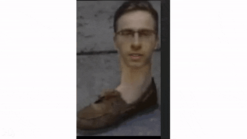 a man 's head is shaped like a shoe and is wearing glasses .