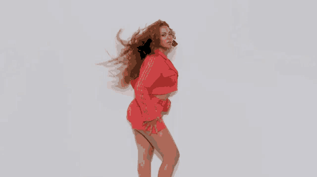 a woman in a red outfit is standing in front of a white background .